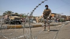 A member of the Iraqi security forces stands guard at a checkpoint, enforcing a curfew due to the COVID-19 coronavirus pandemic, in Baghdad's eastern Sadr City suburb on May 31, 2020. - The Iraqi authorities imposed a week-long curfew to curb the latest increase in infections of coronavirus in the country. (Photo by AHMAD AL-RUBAYE / AFP)